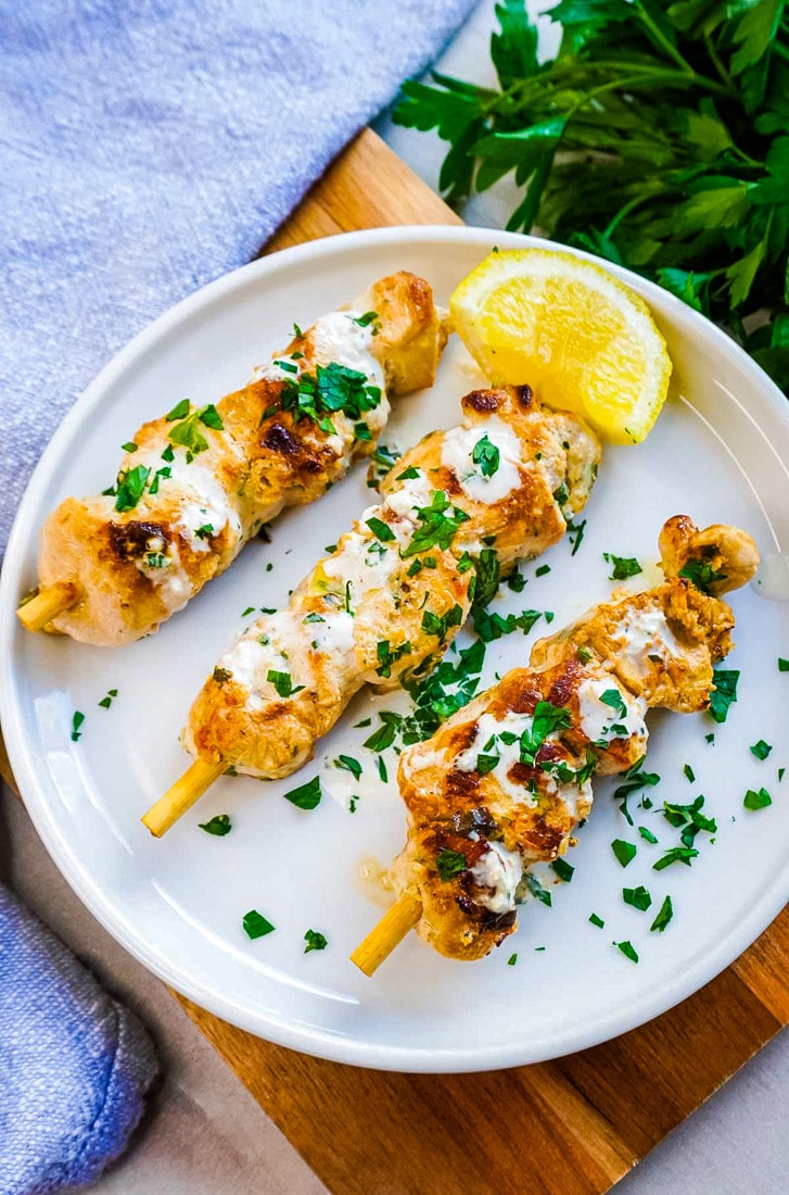 An overhead picture of three Ginger Chicken Skewers on a white plate.