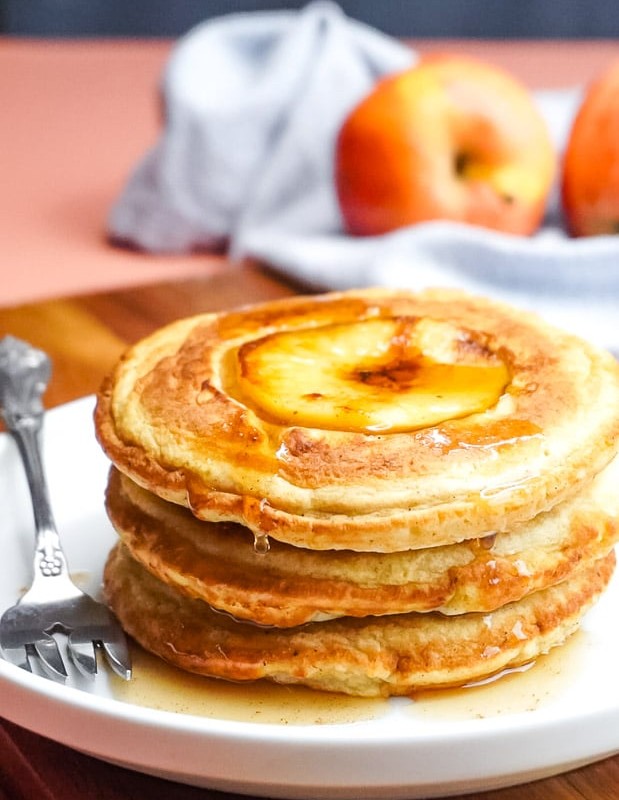 A stack of apple pancakes on a white plate.