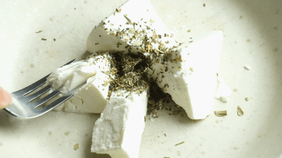 a plate of feta cheese with herbs