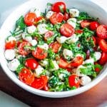 A close up of the finished Caprese Salad in a white serving bowl.