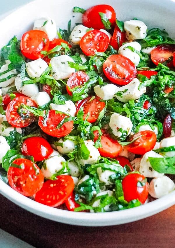 A close up of the finished Caprese Salad in a white serving bowl.