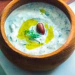 A close up of the finished Tzatziki Sauce in a wooden serving bowl.