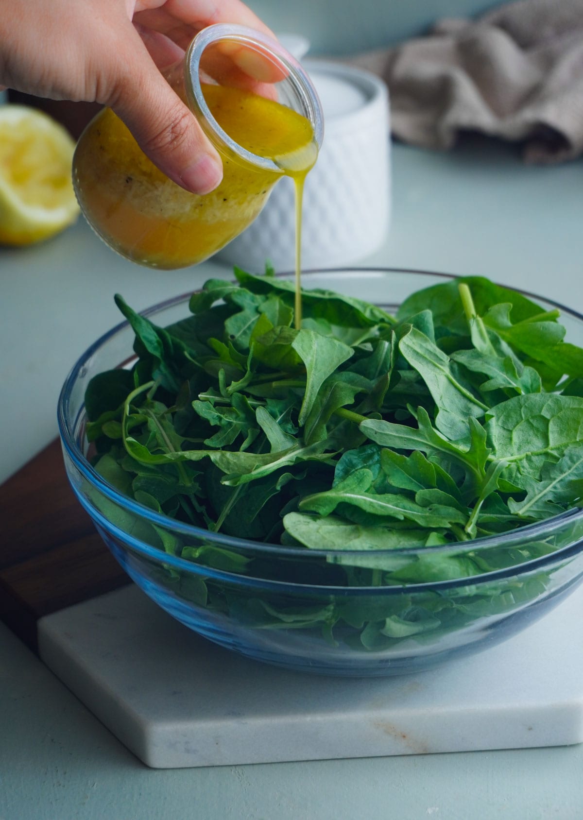 The best simple arugula salad with olive oil dressing in a glass bowl