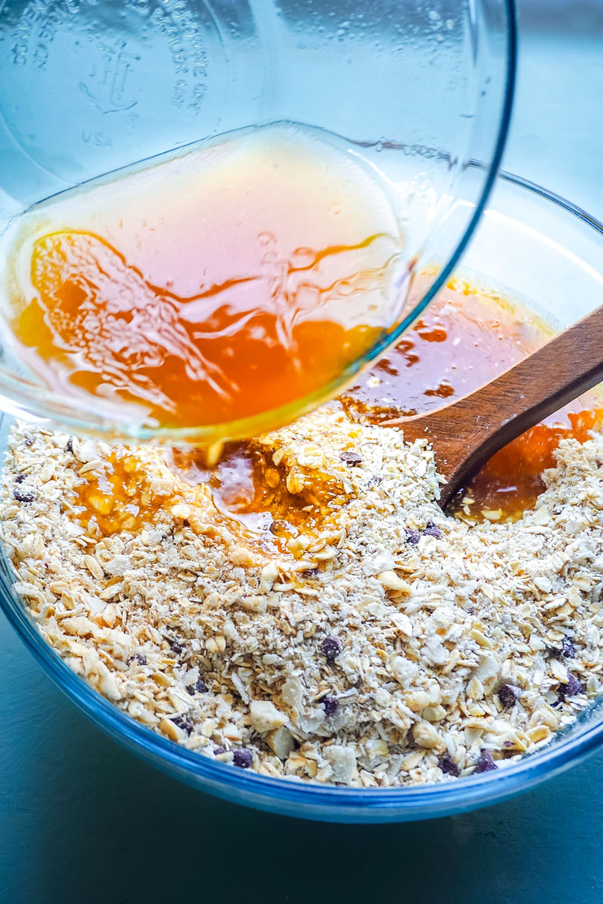 Honey poured into a bowl of oats and coconut.