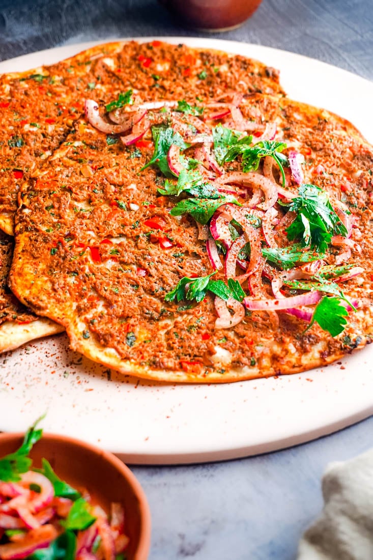 Three of the Lahmacun Turkish Pizzas on a pizza stone.