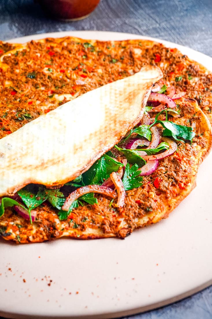 One of the finished Lahmacun Turkish Pizzas folded in half so you can see what the finished crust looks like.