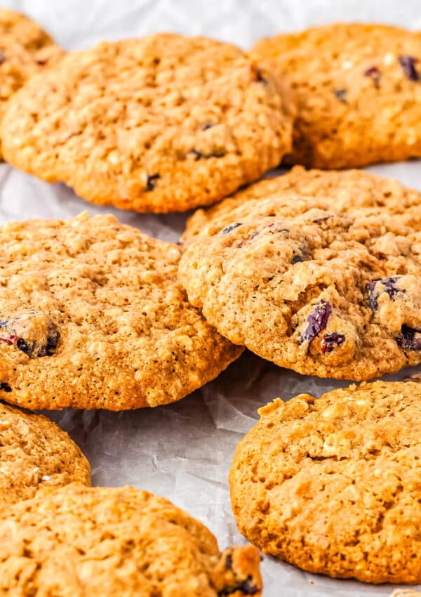 Eight gluten-free cranberry oatmeal cookies on parchment paper.