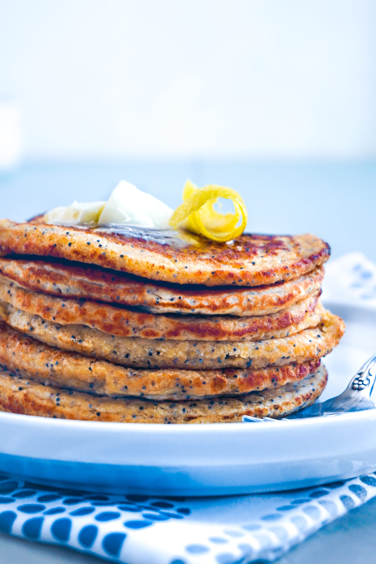 lemon poppy seed pancakes with a white plate and fork
