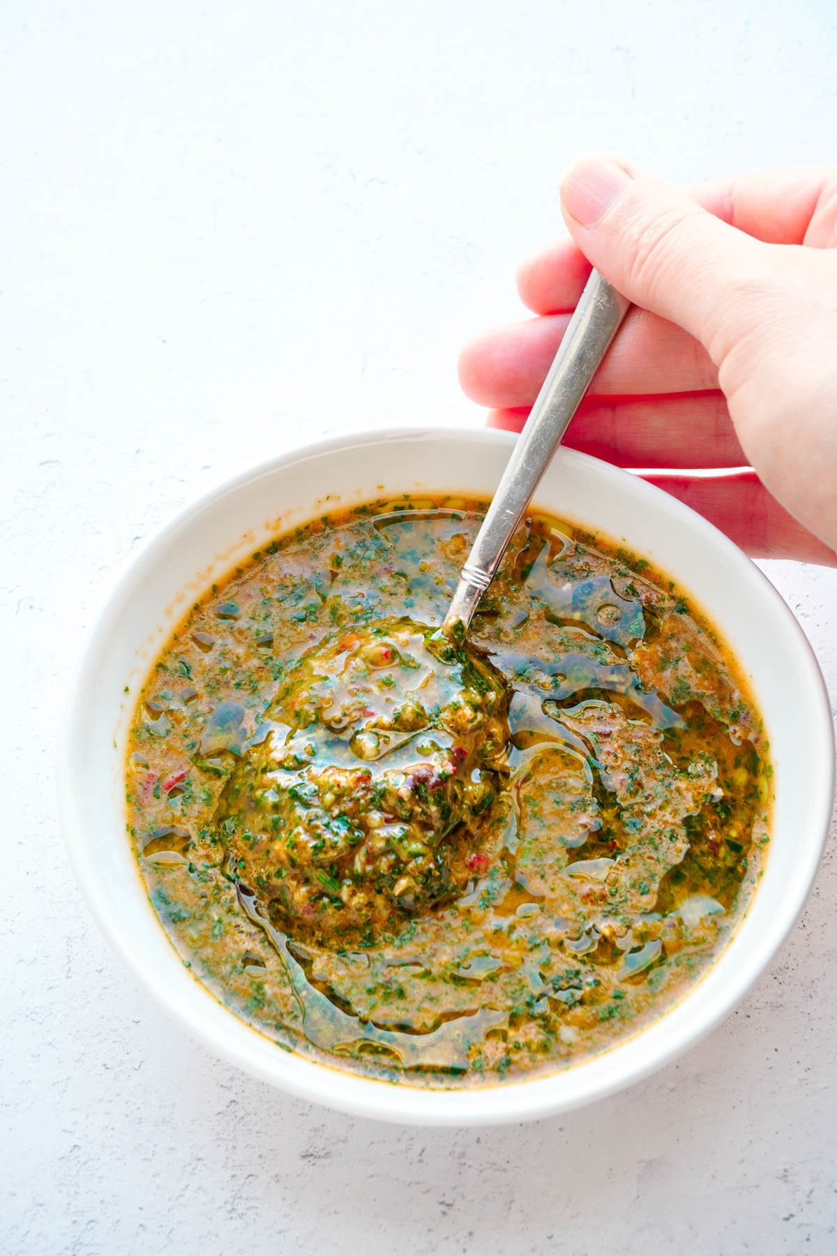 chipotle chimichurri is a bowl with a spoon. 