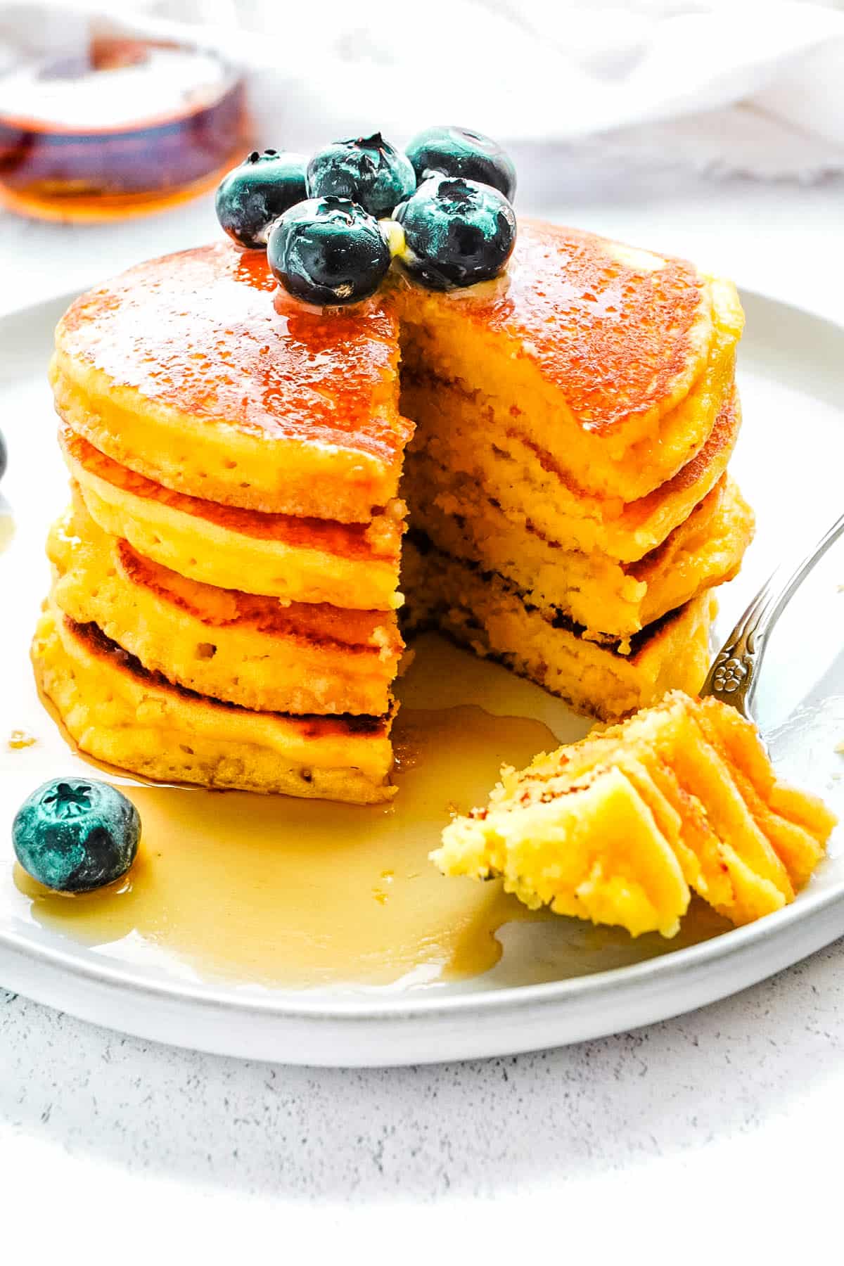 Four Almond Flour Pancakes stacked on top of each other, and they're been cut into so you can see the interior. 