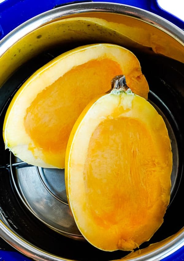 A Spaghetti Squash cut in half inside an Instant Pot before it is cooked.