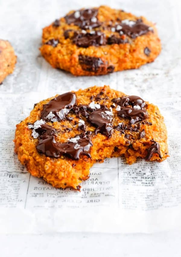 A Sweet Potato Oat Cookie with a bite take out of it and the chocolate on the cookie is nice and melty.