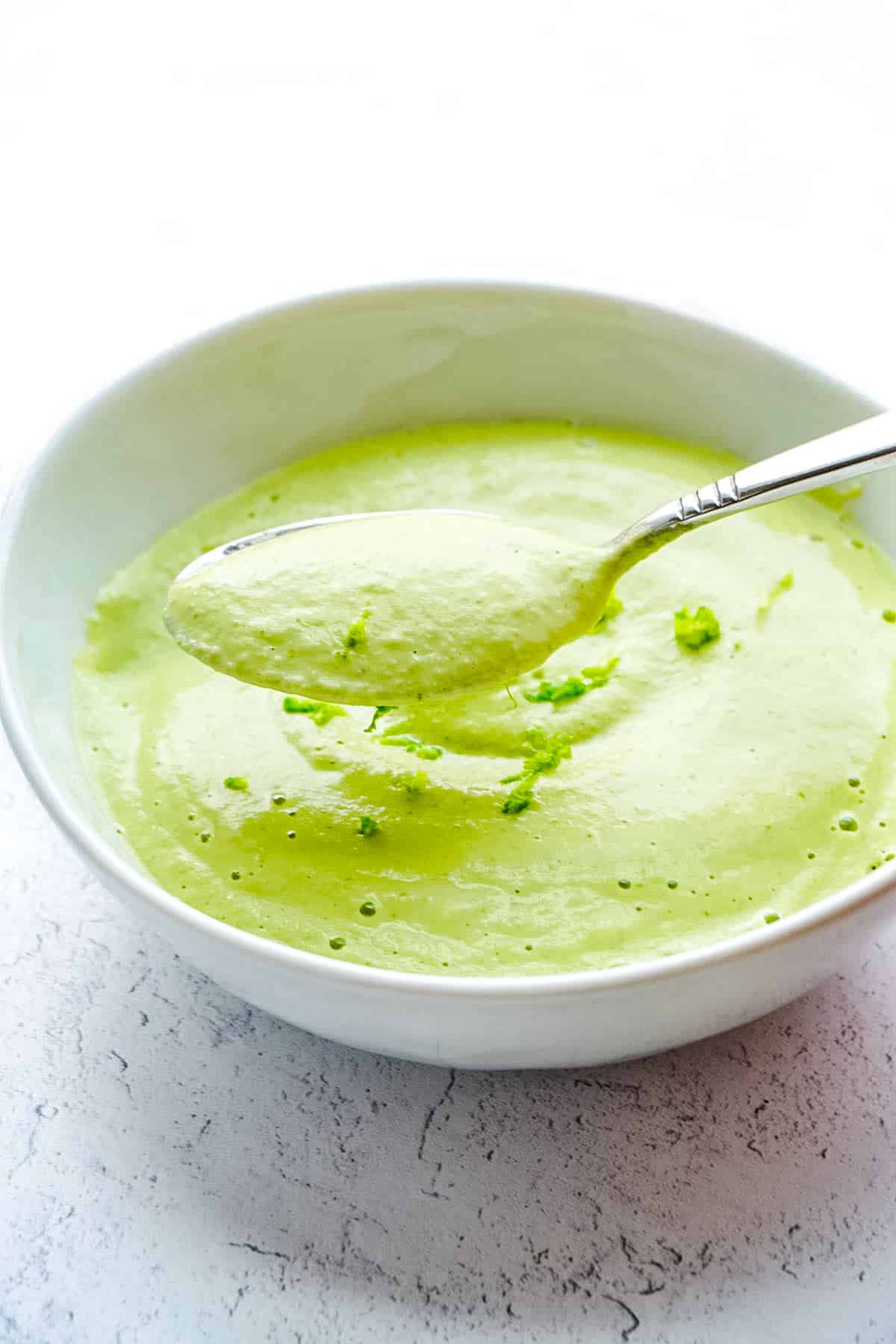 A spoon scooping up from vegan cilantro lime crema.