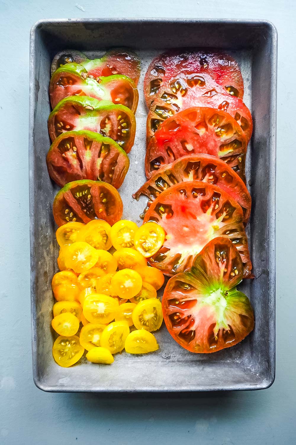 Sliced heirloom Tomatoes in a tin.