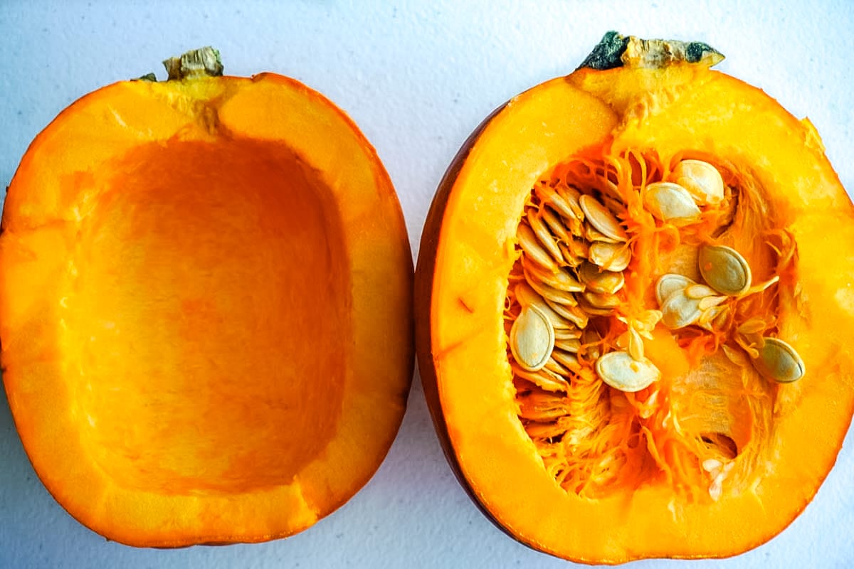 A picture of a pumpkin cut in half with half of the seeds removed.