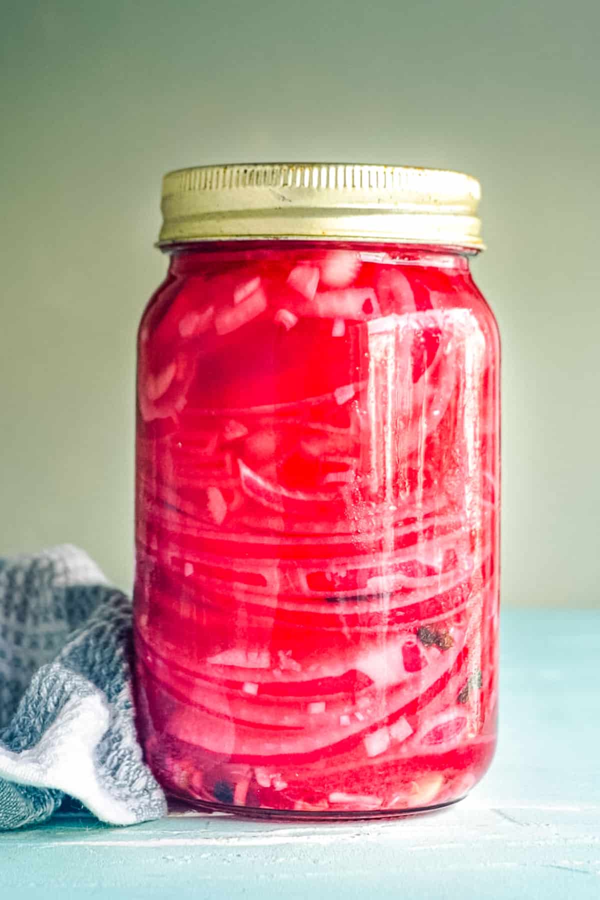 A close up picture of the finished Pickled Red Onions recipe in a canning jar.