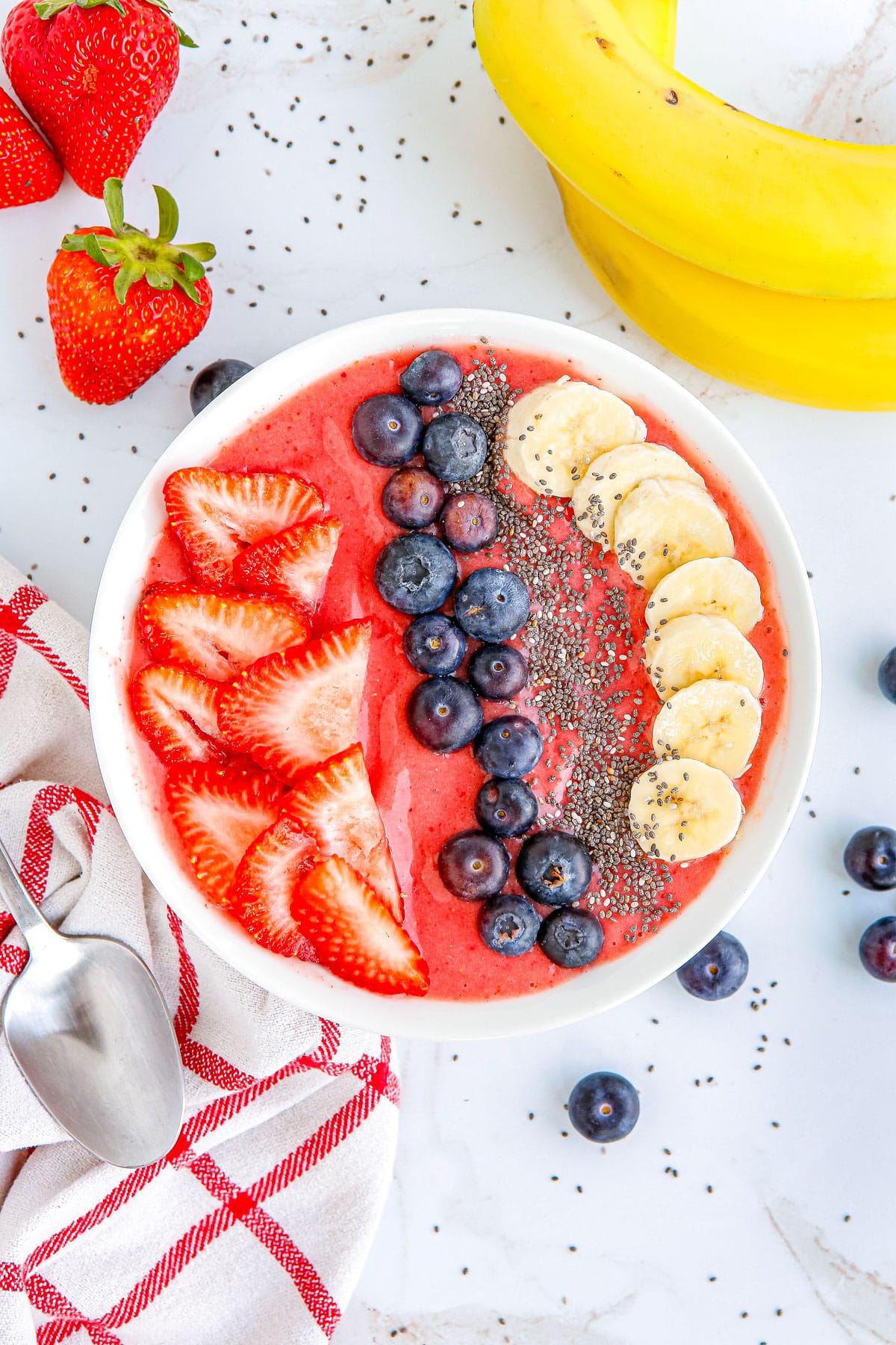 The finished Strawberry Smoothie Bowl on a counter in a white bowl. 
