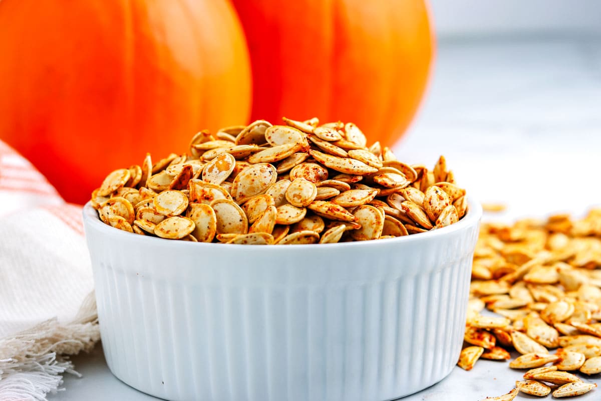 The finished roasted pumpkin seeds recipe in a white serving bowl.