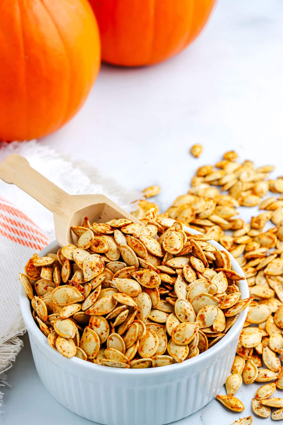 A serving spoon in a bowl of toasted pumpkin seeds.