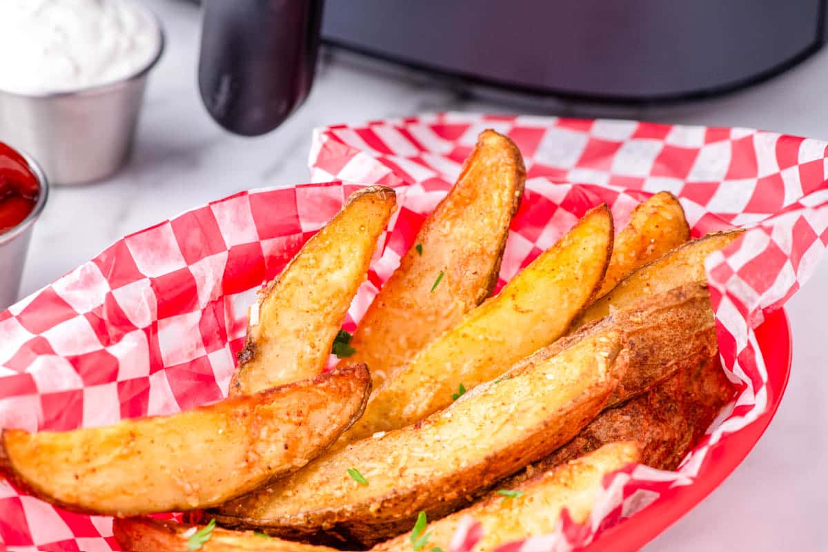 Potato Wedges in a basket lined with parchment paper.