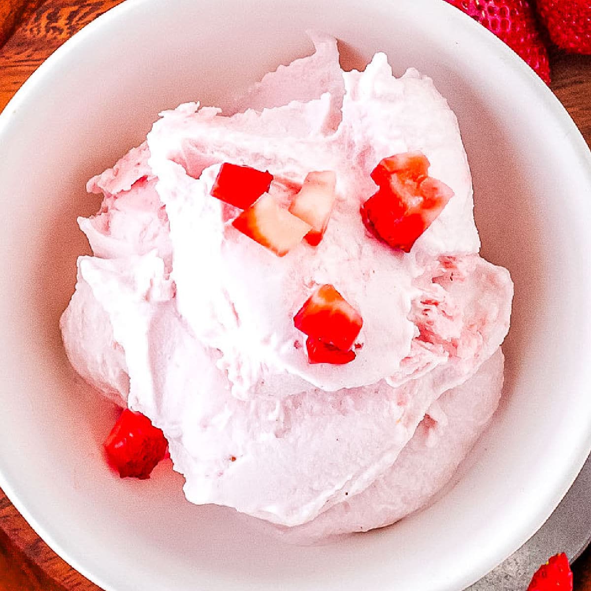 A scoop of strawberry ice cream with strawberries on it.