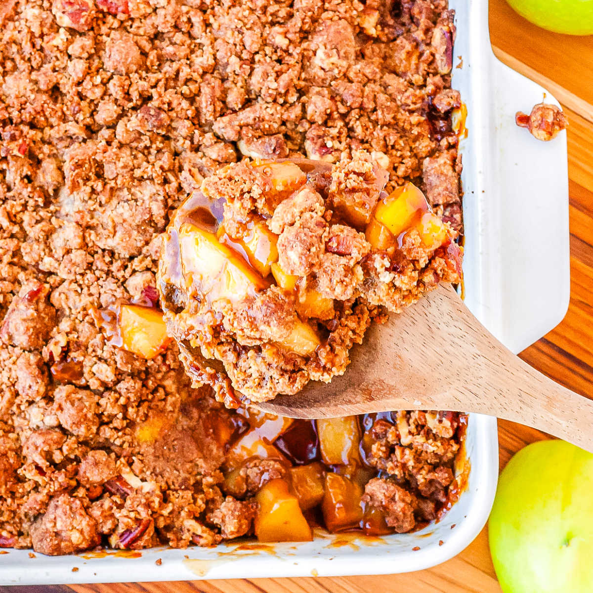 Some gluten-free apple crumble scooped from a baking dish.