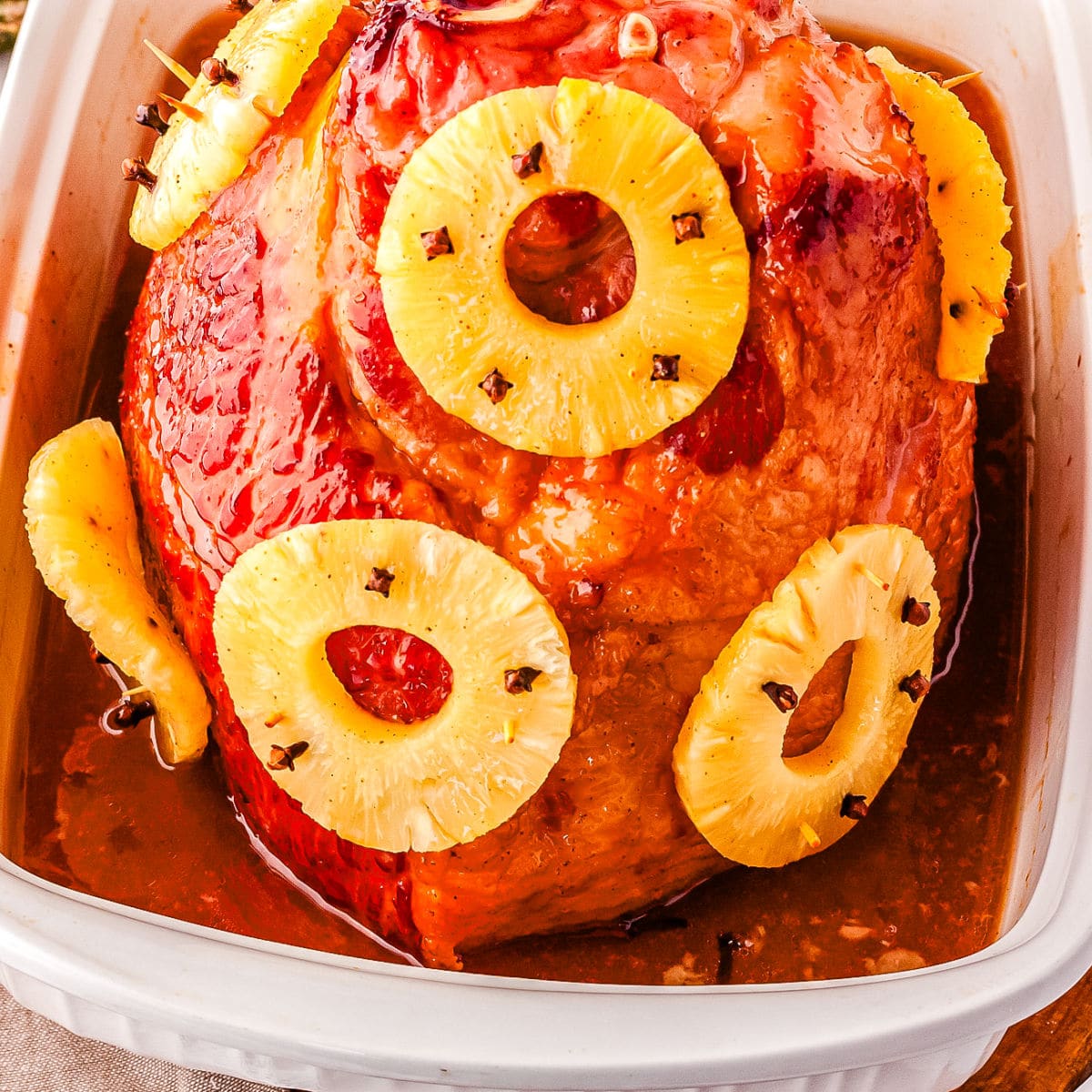 A Honey Glazed Ham with Pineapple in a baking dish.