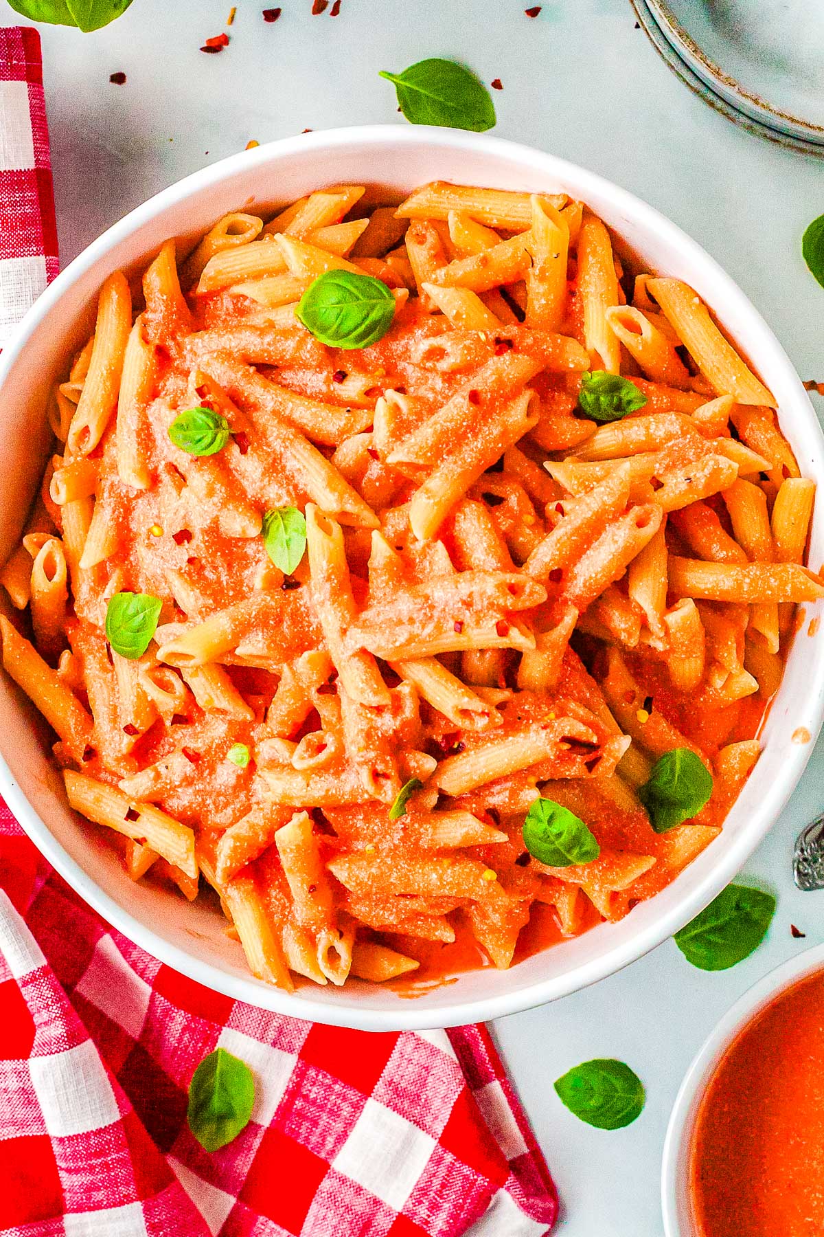 Creamy cottage cheese pasta sauce coating penne pasta, garnished with fresh basil leaves.